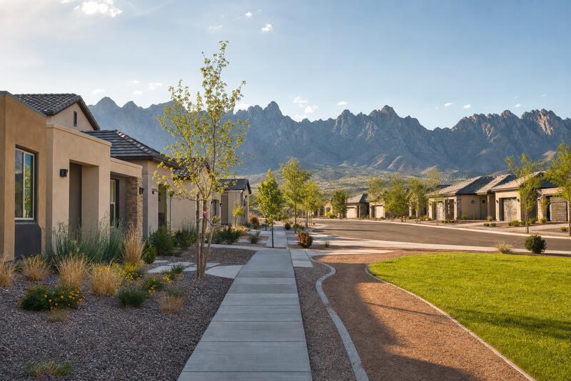 Street of new stucco homes with the mountains behind