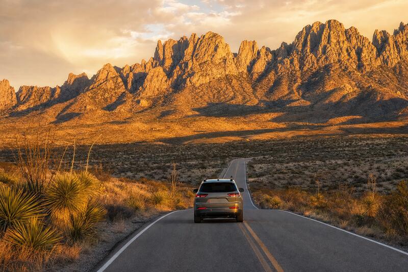 Car on a desert highway heading toward the mountains